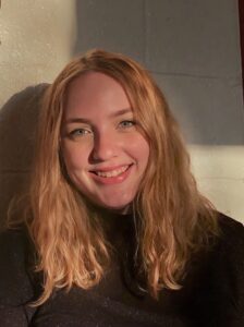 photo of avery troutman, strawberry-blond hair, smiling wearing black shirt